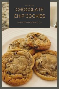 Chocolate chip cookies on a plate with a glass of cold milk.