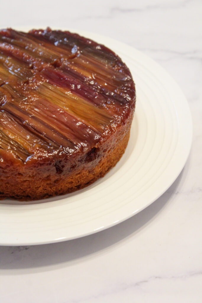 Upsidedown cake on a plate on a light background ready to be served.